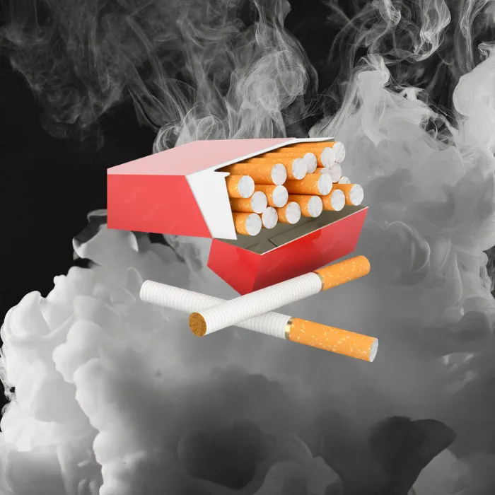 Cigarette pack with loose cigarettes on smoky black background